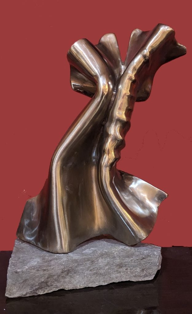 Polished metallic abstract sculpture on stone base, modern artistic metalwork, contemporary art piece, metal sculpture for interior decor, Richard Comparey artwork signature.